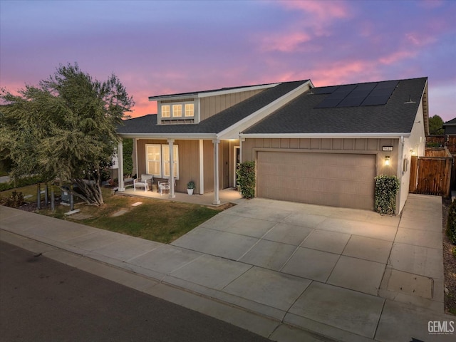 9642 Silver Falls Ln, Shafter, CA 93263 - view of front of house with an attached garage, solar panels, driveway, covered porch, and roof with shingles
