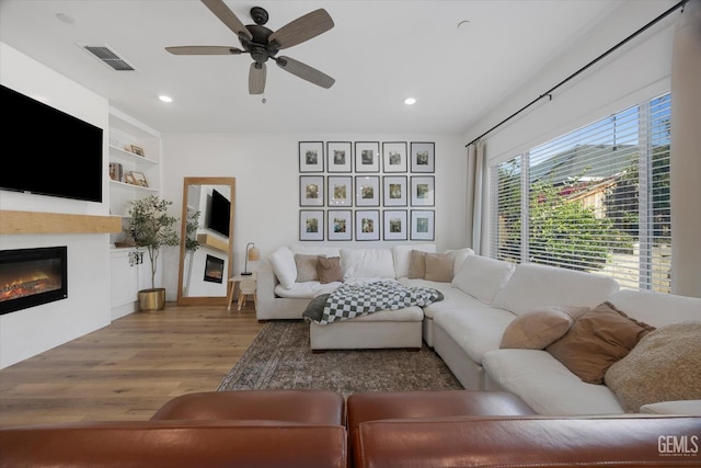 9642 Silver Falls Ln, Shafter, CA 93263 - living room featuring a glass covered fireplace, light wood-style flooring, ceiling fan, and recessed lighting