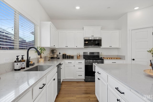 9642 Silver Falls Ln, Shafter, CA 93263 - kitchen with stainless steel appliances, a sink, light stone counters, white cabinets, and recessed lighting