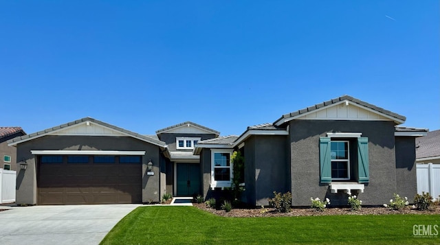 view of front of house with stucco siding, driveway, a front yard, and a garage