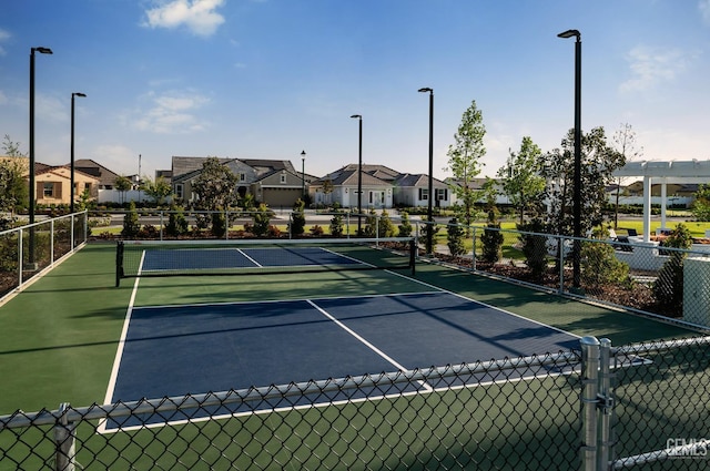 view of sport court featuring fence and a residential view