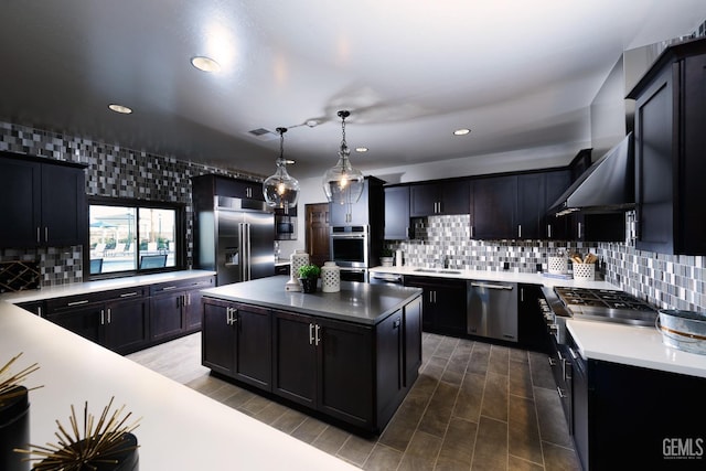 kitchen featuring a sink, stainless steel appliances, recessed lighting, decorative backsplash, and a kitchen island