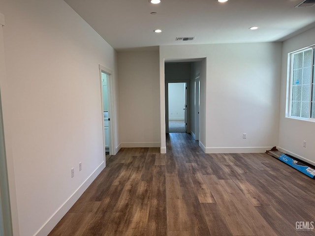 unfurnished room featuring recessed lighting, baseboards, visible vents, and dark wood finished floors