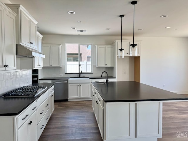 kitchen featuring visible vents, a sink, dark countertops, and stainless steel appliances