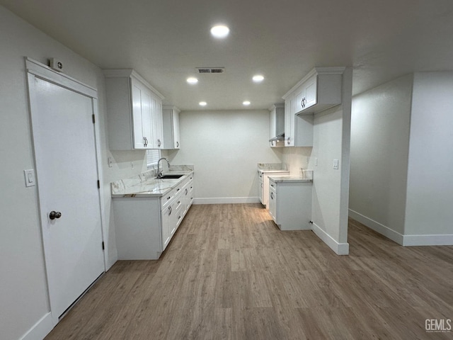 320 10th St, Mc Farland, CA 93250 - kitchen featuring visible vents, baseboards, light wood-style floors, light countertops, and a sink