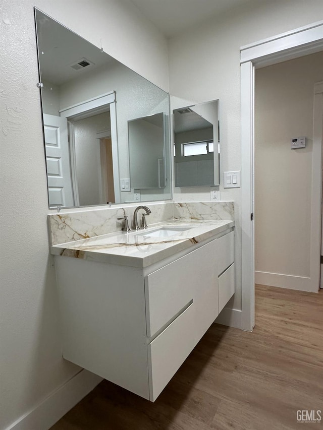 320 10th St, Mc Farland, CA 93250 - bathroom with visible vents, baseboards, wood finished floors, and vanity