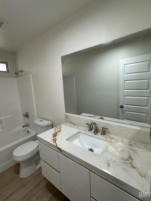 320 10th St, Mc Farland, CA 93250 - bathroom featuring visible vents, vanity, wood finished floors, toilet, and shower / tub combination