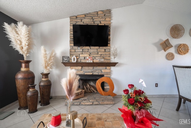 living room with baseboards, lofted ceiling, tile patterned flooring, a stone fireplace, and a textured ceiling