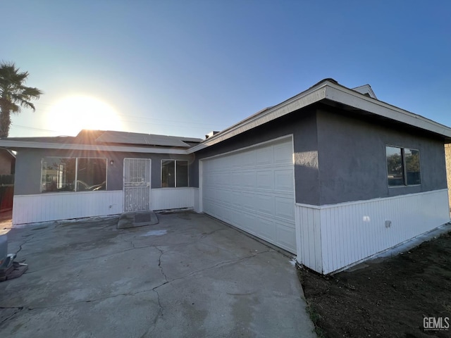 view of front of property featuring solar panels and a garage