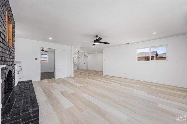 unfurnished living room featuring a brick fireplace, ceiling fan, healthy amount of natural light, and recessed lighting