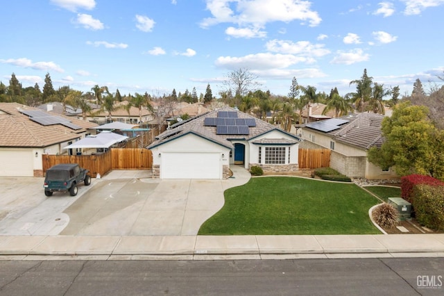 view of front of property with a front lawn, stone siding, fence, a garage, and solar panels