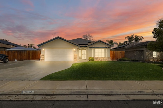 ranch-style house featuring a garage, stucco siding, a front yard, and fence