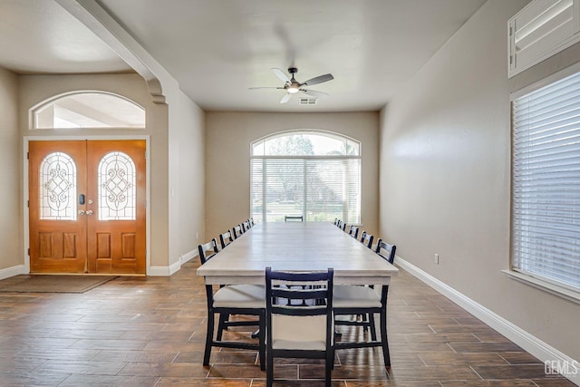 dining space featuring visible vents, a ceiling fan, baseboards, and wood tiled floor