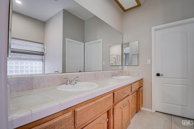 full bath with tile patterned flooring, double vanity, and a sink