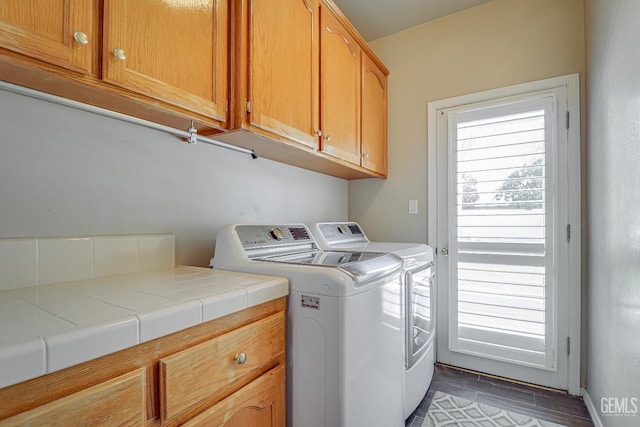 washroom featuring cabinet space, wood finished floors, and separate washer and dryer