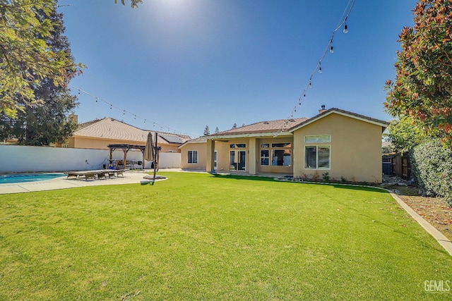 rear view of house featuring a fenced backyard, stucco siding, a pergola, and a patio