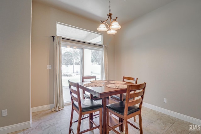 dining space featuring baseboards and a notable chandelier