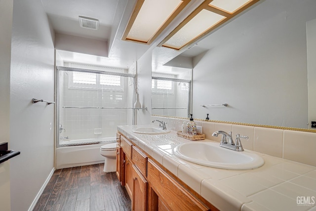 bathroom with a sink, visible vents, toilet, and wood finished floors