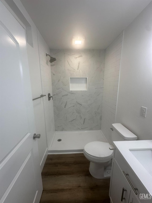 bathroom featuring vanity, a stall shower, wood finished floors, and toilet