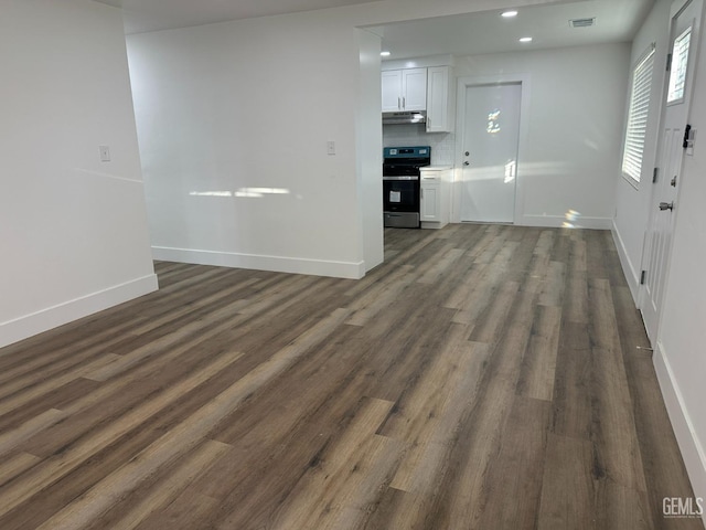 interior space with baseboards, visible vents, dark wood finished floors, and recessed lighting