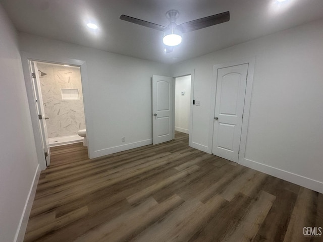 unfurnished bedroom featuring baseboards, ceiling fan, ensuite bathroom, and wood finished floors