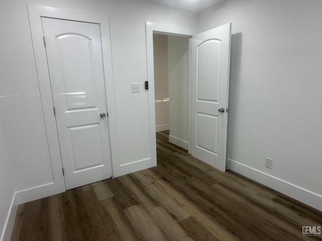 unfurnished bedroom featuring dark wood finished floors and baseboards