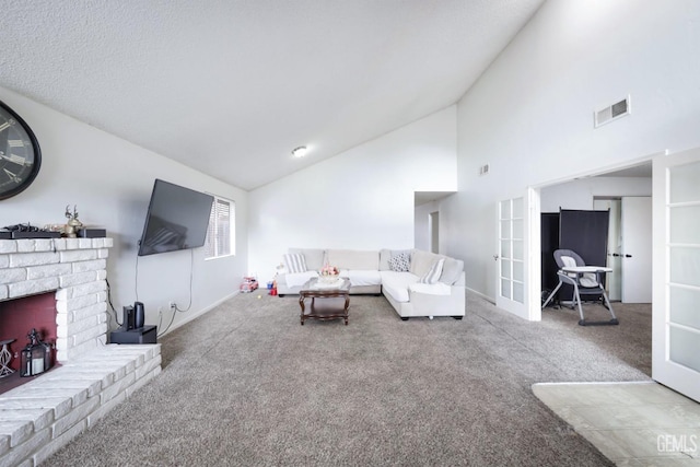 carpeted living room featuring a fireplace, high vaulted ceiling, and french doors