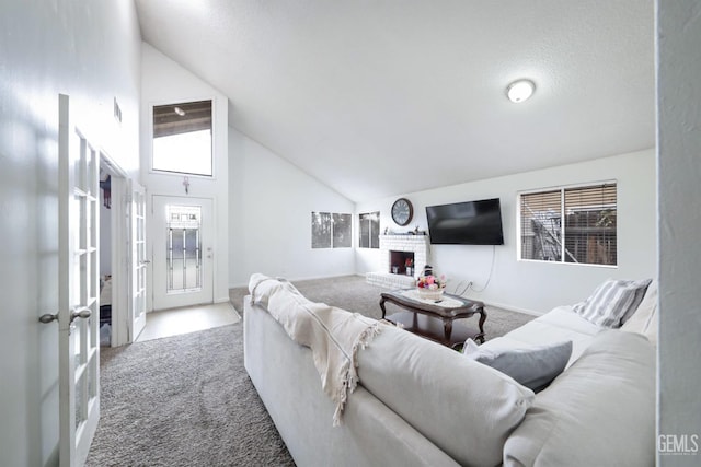 living room featuring a fireplace, high vaulted ceiling, french doors, and carpet