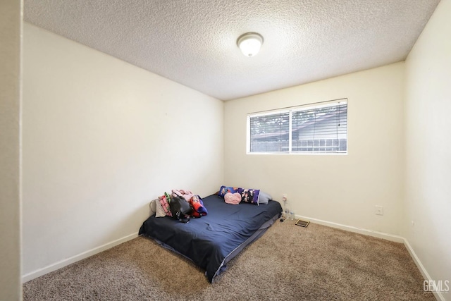 bedroom with carpet and a textured ceiling