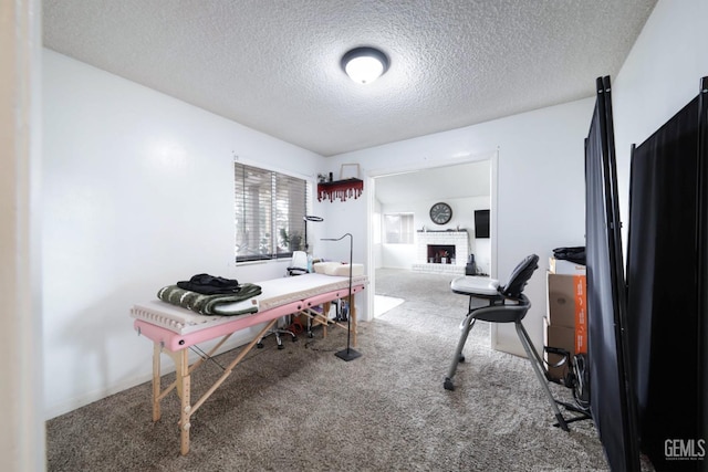 office area featuring a fireplace, a textured ceiling, and carpet flooring