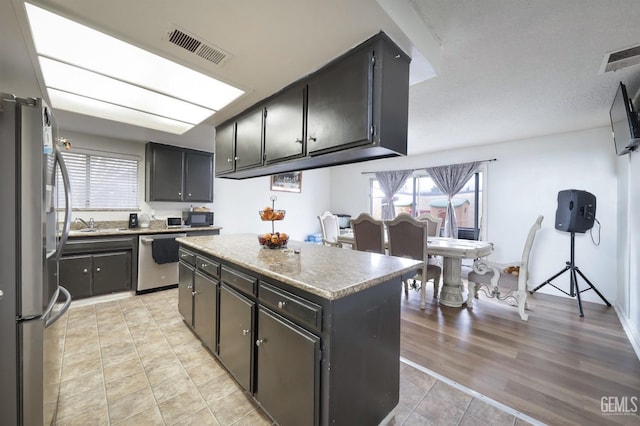 kitchen featuring light wood-type flooring, stainless steel appliances, and a kitchen island