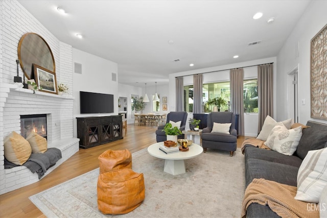 6707 Park W Cir, Bakersfield, CA 93308 - living area with wood finished floors, a brick fireplace, and recessed lighting