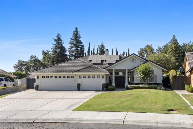 6707 Park W Cir, Bakersfield, CA 93308 - view of front of home featuring an attached garage, roof mounted solar panels, stucco siding, and driveway