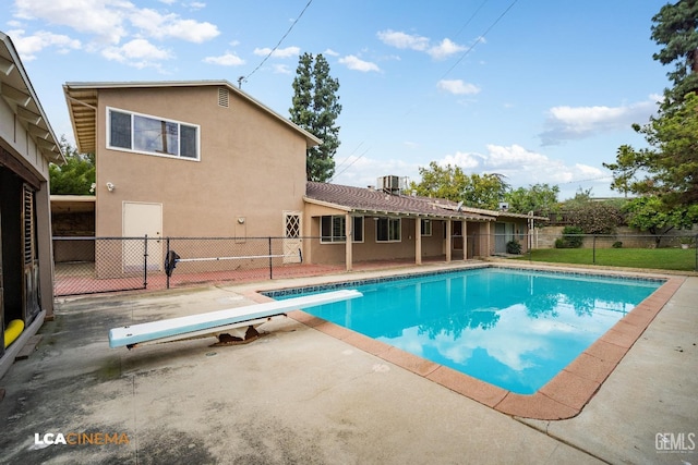 view of pool with a patio area, a diving board, fence, and a fenced in pool