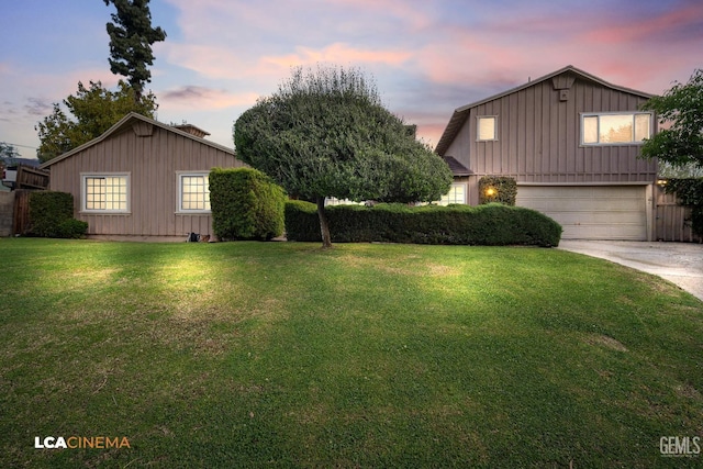 view of front of home featuring a front yard, board and batten siding, concrete driveway, and a garage