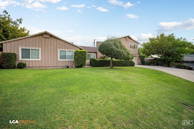ranch-style home with board and batten siding, concrete driveway, and a front lawn