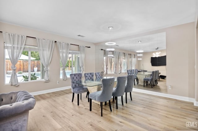 dining space featuring baseboards, visible vents, and light wood finished floors