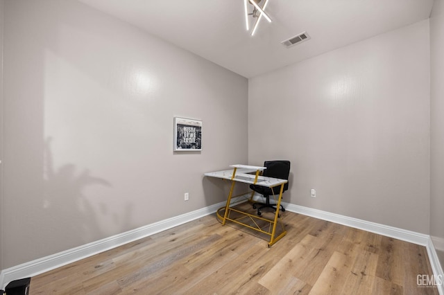 home office featuring baseboards, visible vents, and wood finished floors