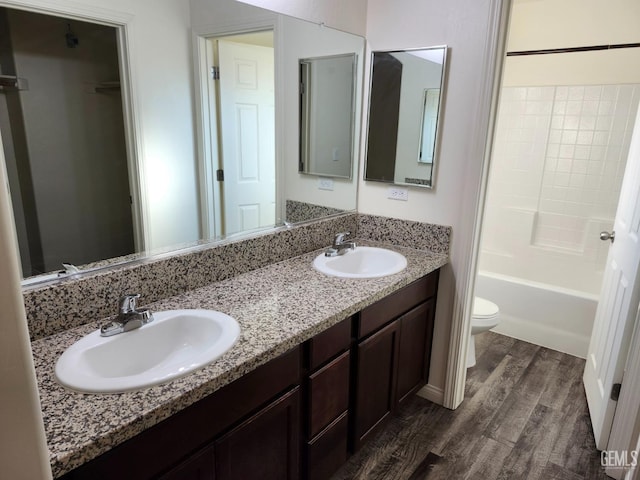 full bathroom with shower / bath combination, vanity, hardwood / wood-style flooring, and toilet