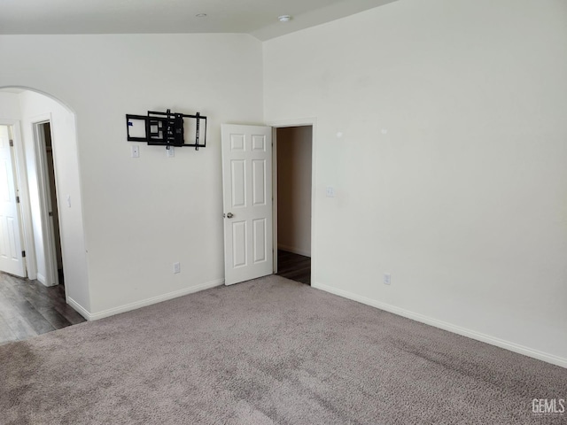 empty room with carpet floors and lofted ceiling