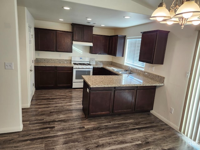 kitchen featuring hanging light fixtures, gas range gas stove, a notable chandelier, dark hardwood / wood-style flooring, and kitchen peninsula