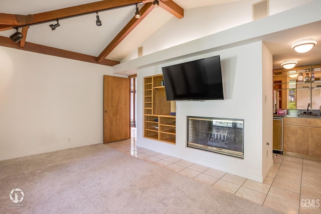 2221 Myrtle St, Bakersfield, CA 93301 - unfurnished living room with light tile patterned floors, vaulted ceiling with beams, a sink, light carpet, and a glass covered fireplace