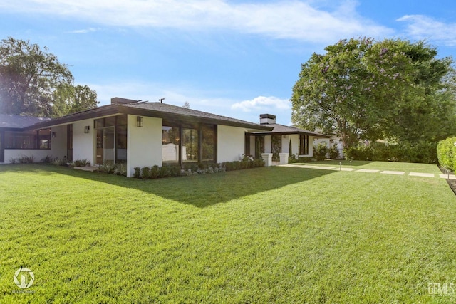 2221 Myrtle St, Bakersfield, CA 93301 - rear view of property with stucco siding, a chimney, and a yard