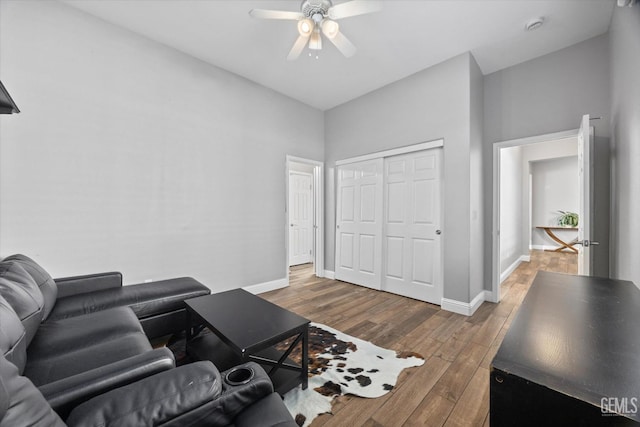 living area featuring ceiling fan, baseboards, and wood finished floors