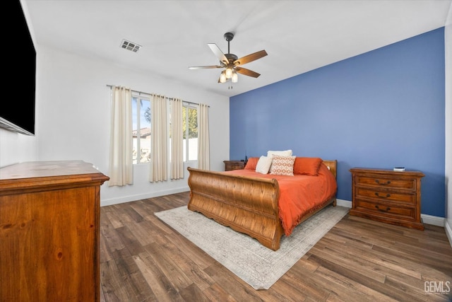 bedroom with dark wood-style floors, visible vents, ceiling fan, and baseboards