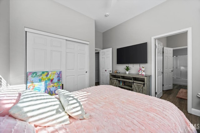 bedroom featuring ensuite bath, baseboards, dark wood finished floors, and a closet