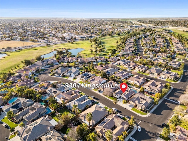 aerial view featuring view of golf course, a water view, and a residential view