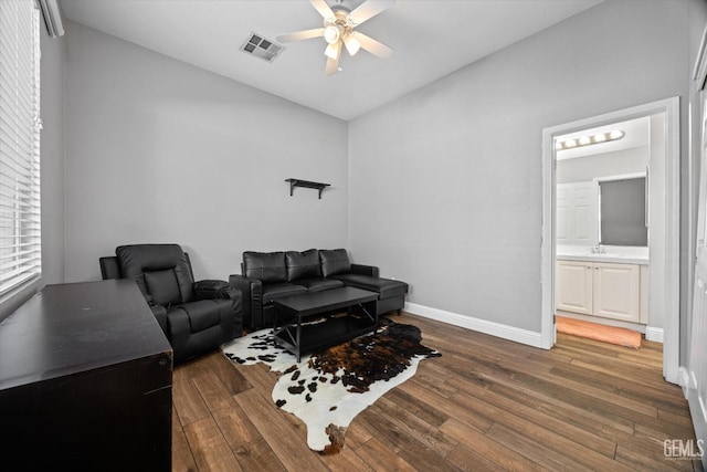 living room featuring baseboards, ceiling fan, visible vents, and wood finished floors