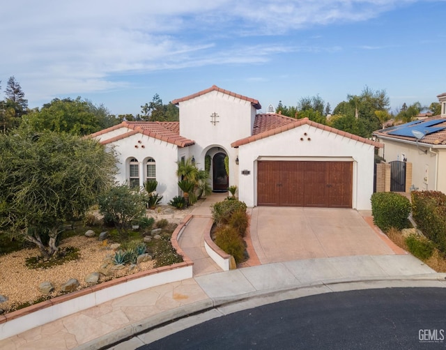 mediterranean / spanish-style home featuring stucco siding, driveway, a gate, a garage, and a tiled roof