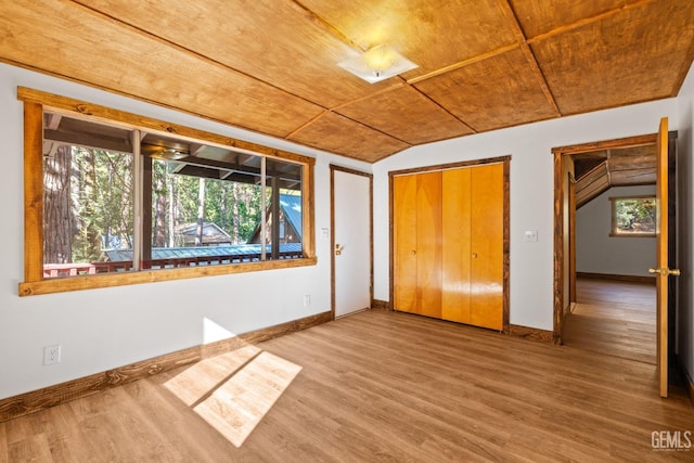 unfurnished bedroom with hardwood / wood-style floors, lofted ceiling, wood ceiling, and multiple windows